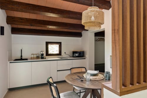Cuccinetta moderna con mobili bianchi, travi in legno e zona pranzo presso Dimora Silva Nature Suites a San Martino delle
