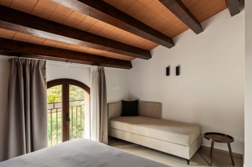 Camera moderna a Dimora Silva 7 con travi in legno a vista, daybed, porte in vetro ad arco con vista sulle montagne di San Martino
