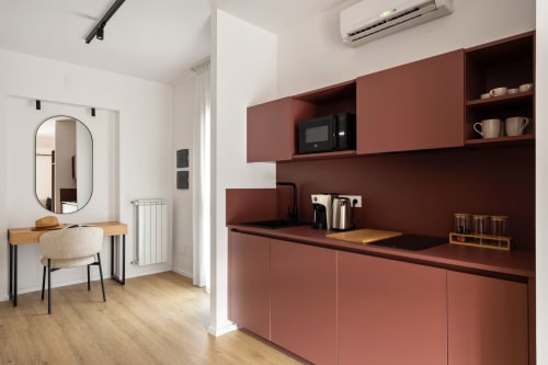 Moderna cucina in studio con mobili color terracotta, scrivania in legno e specchio presso Dimora Silva Nature Suites, San Martino delle