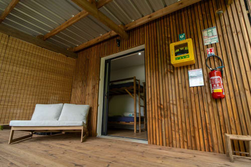 Façade de la cabane en bois du Gîte Eden du randonneur avec banc, porte, extincteur, Entre-Deux