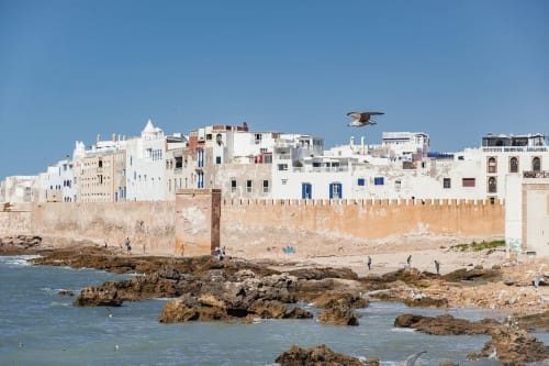 Médina fortifiée côtière aux murs blancs, portes bleues et remparts anciens surplombant une plage rocheuse, Essaouira
