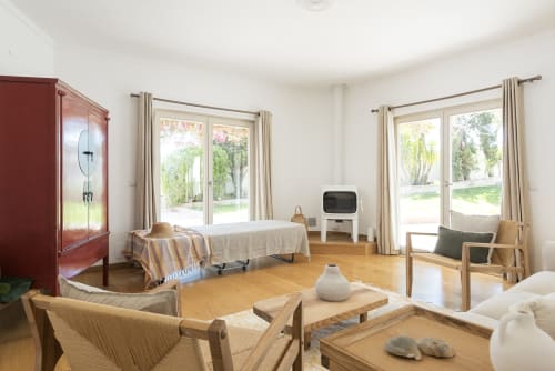 Bright villa living room at RB Algarve with wooden furniture, garden views through patio doors, and traditional Portuguese