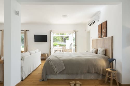 Spacious bedroom in RB Algarve villa with king bed, lounge area, wall-mounted TV, and glass doors opening to pool view