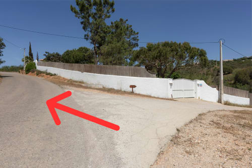 Driveway at RB Algarve villa in Boliqueime with white fence, trees, and parking area