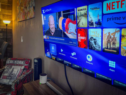 Televisor OLED LG 4K mostrando servicios de streaming en departamento amueblado de Santiago de Querétaro con taza de café sobre escritorio