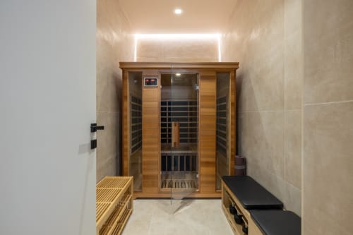 Moderna cabina sauna a infrarossi con interno in legno in zona wellness di appartamento romano con illuminazione ambientale