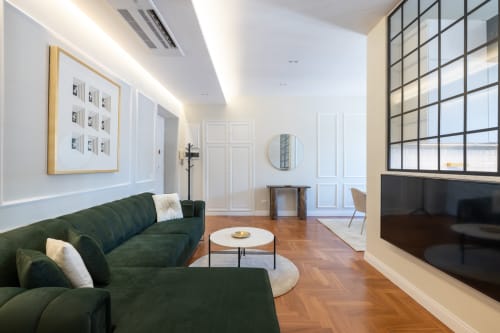 Moderno soggiorno negli Lovely Rome Apartments Studio 71 con divano verde curvo, pavimenti in legno e vista sui monumenti