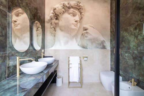 Lussuoso bagno in appartamento romano con busto in marmo classico, doppi lavabi, rubinetteria dorata e marmo verde