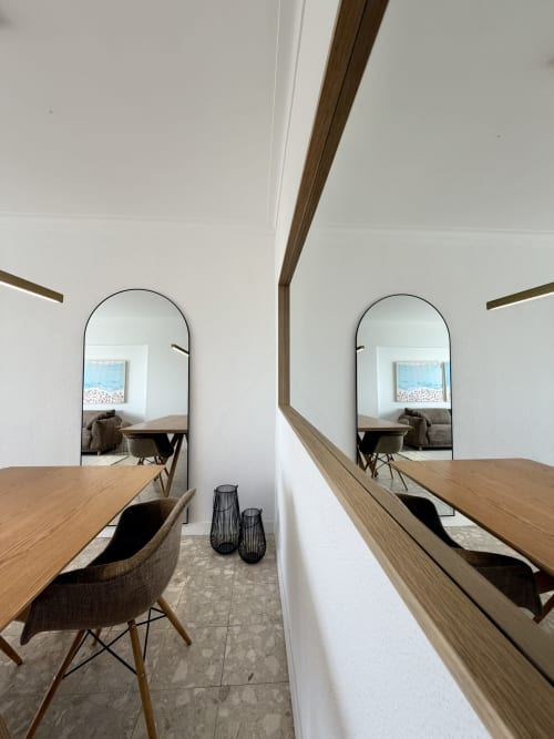 Área de jantar moderna com espelhos arqueados no apartamento Republica do Sul em Aroeira, Portugal, com vista para o mar