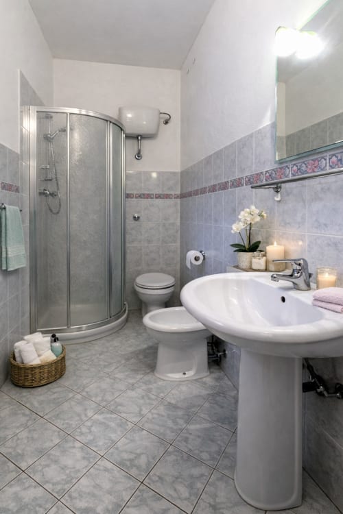 Bagno moderno con lavabo su colonna, box doccia curvo e rivestimenti decorativi presso I Castagnini B&B, Montecatini Val di