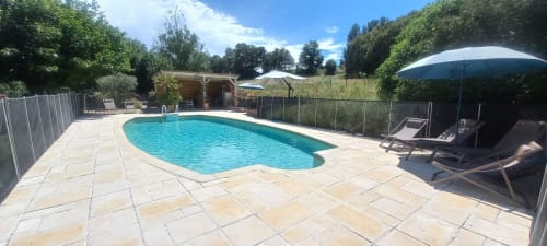 Poolanlage des Domaine Bellavigne mit Liegen und Sonnenschirm in Forcalquier, Frankreich