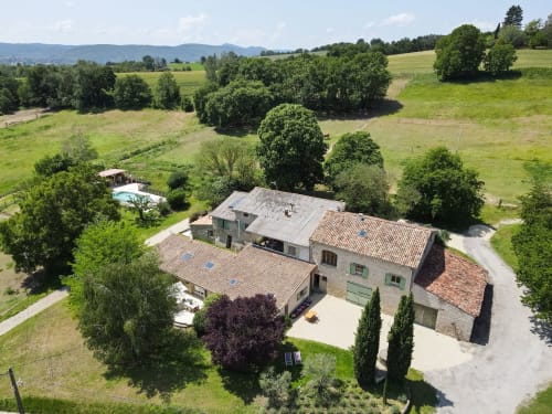 Luftaufnahme des Domaine Bellavigne Gîtes et Spa in Forcalquier, Frankreich mit Steingebäuden, Pool und Landschaft