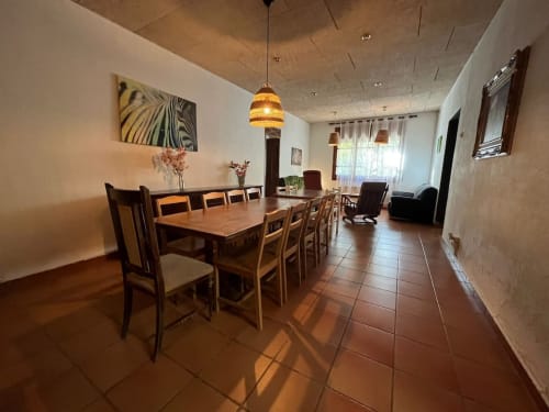 Amplio comedor de la casa rural NIU HOUSE en L'Amagatall de Cal Tonedor, Vallgorguina con mesa de madera, sillas y montaña