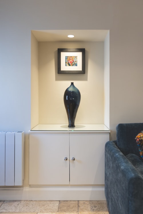 Built-in display niche at The Ford Apartment Perth with dark ceramic vase and framed artwork above white cabinetry