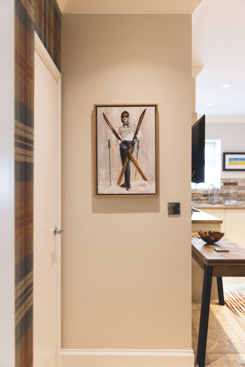 Modern hallway at The Ford Apartment Perth with framed ski-themed artwork on beige wall and dark wooden door