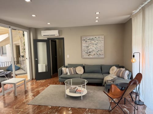 Modern living room at The Ruzafa Market Apartment in Valencia with gray sofa, round coffee table, and city views through