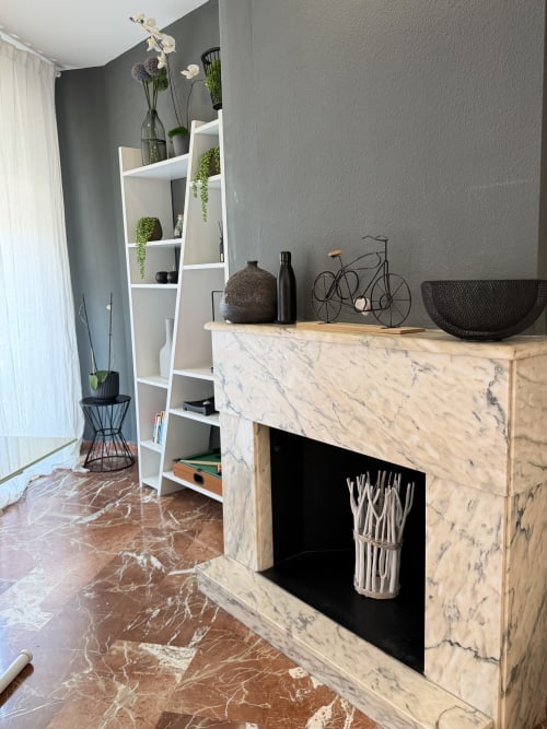 Modern Valencia apartment living room with marble fireplace, white shelving unit, and gray textured walls in The Ruzafa