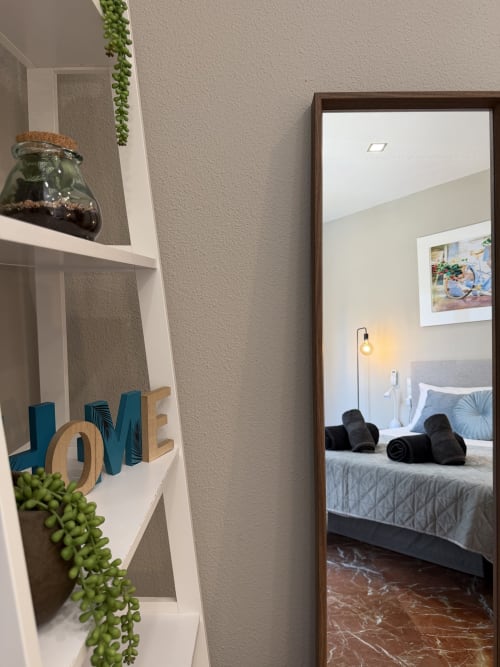 Stay Gest Ruzafa Market Apartment Valencia: bedroom with mirror, LOVE decor, plants, and city view access