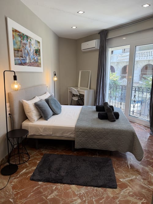Modern bedroom in The Ruzafa Market Apartment, València, with city views, double bed, pendant lighting, and balcony access
