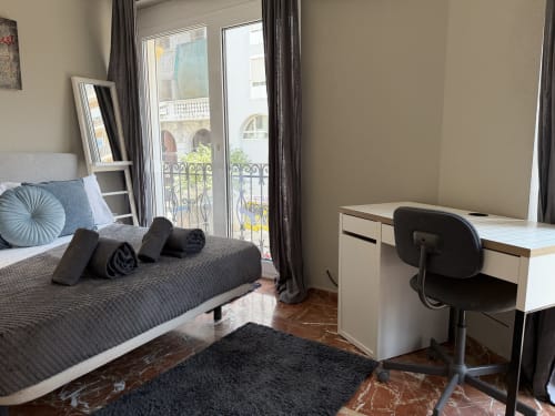 Modern bedroom in Ruzafa Market Apartment, València, with bed, desk, city view balcony, and contemporary furnishings
