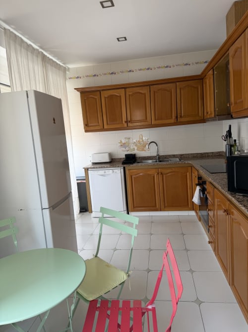 Modern kitchen with wooden cabinets, stainless steel appliances, and dining area in Ruzafa Market Apartment, Valencia