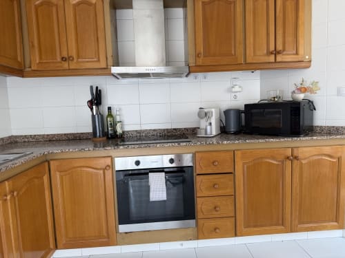 Modern kitchen in The Ruzafa Market Apartment, València, with wooden cabinetry, stainless steel appliances, and granite
