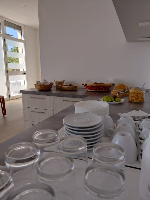 Makasa B&B kitchen setup in Villapiana with dinnerware, glassware, and baskets on counter
