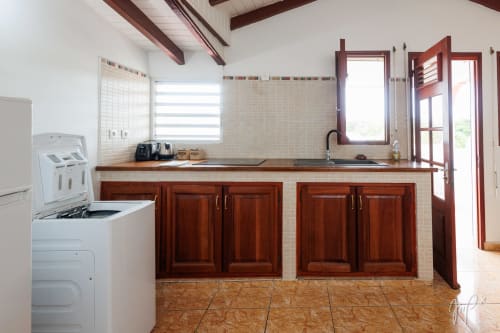Cuisine moderne de l'appartement Anthurium à Otantik Caribbean, Saint-Louis, avec armoires en bois et carrelage