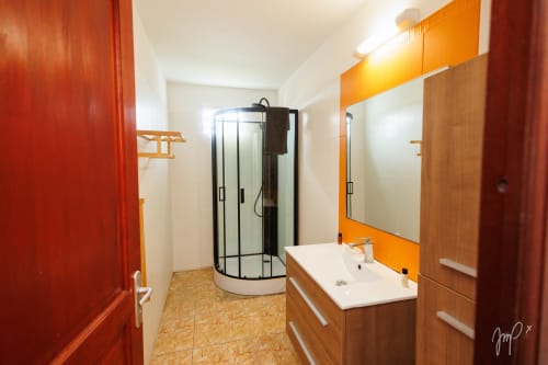 Salle de bains moderne de l'appartement Anthurium à l'hôtel Otantik Caribbean, Saint-Louis, avec vanité en bois et douche à l'italienne