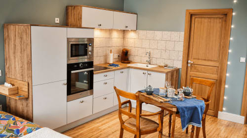 Cuisine aménagée d'Ô de Mer à Sangatte : mobilier blanc, finitions bois, table à manger et four intégré près de la plage