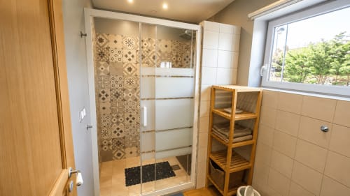 Salle de bain moderne avec douche à l'italienne, carrelage géométrique, porte en bois et étagère de rangement à Ô de Mer à Sangatte