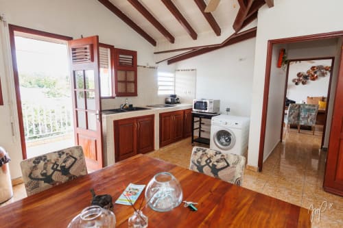 Authentique appartement caribéen à Saint Louis avec cuisine ouverte, table à manger et vue sur la ville depuis le balcon
