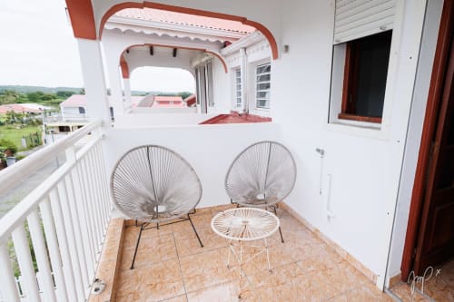 Balcon moderne à Otantik Caribbean avec fauteuils tressés et vues sur la ville de Saint Louis