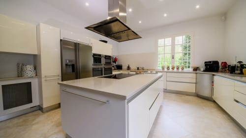 Modern white kitchen with island in Domaine de Bize Mirepoix vacation rental, Ariège Occitanie
