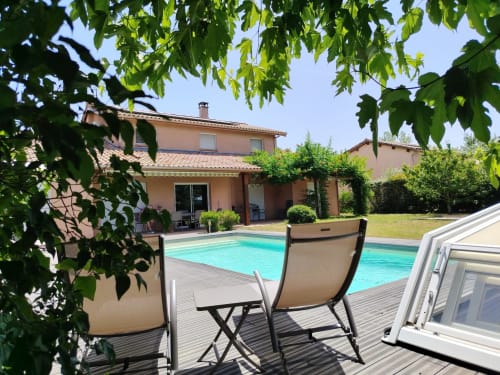 Beauregard B&B pool area with lounge chairs, wooden deck, and terracotta villa in Donneville, France