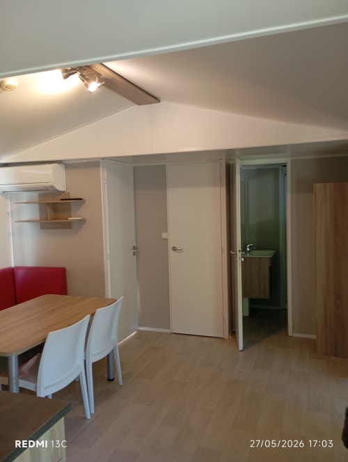 Intérieur du mobilhome au Clocher De Neyran avec coin repas, kitchenette et accès à la salle de bains