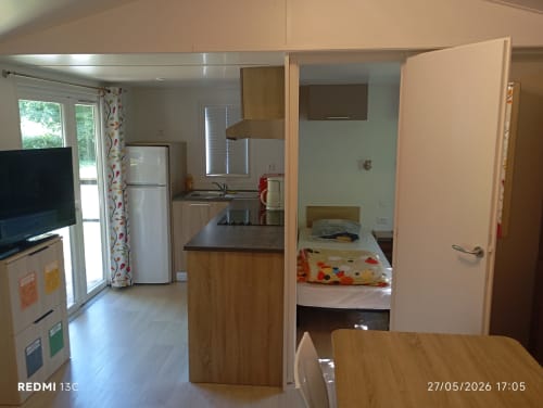 Intérieur du mobil-home Le Clocher De Neyran avec cuisine, salle à manger, chambre et séjour donnant sur le jardin