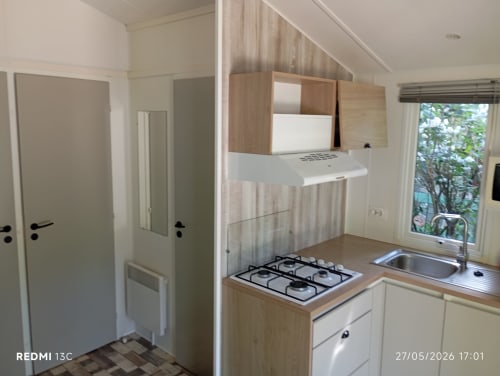 Cuisine moderne du Mobilhome 21 au Clocher De Neyran, Saint Gervais sur Mare, avec cuisinière gaz, évier et meubles en bois