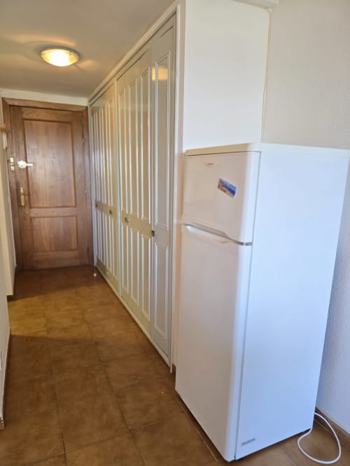 Couloir de cuisine avec réfrigérateur et placard intégré dans appartement en bord de mer, Roses