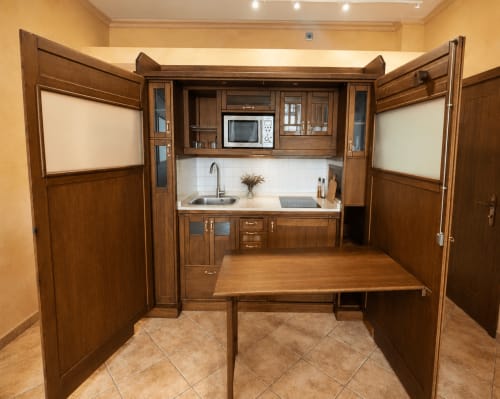 Cocina compacta en apartamento frente al mar de Holibai Baiona con muebles de madera, mesa de comedor y vistas al mar