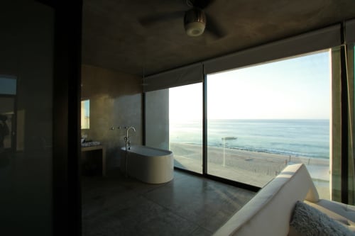 Baño de suite frente a playa con vista al océano en Vidasoul, La Vinorama, México con bañera moderna y ventanales de piso a techo