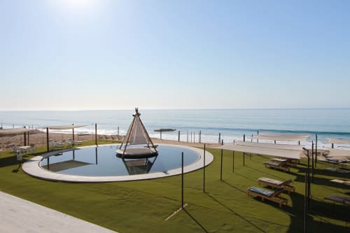 Resort beachfront Vidasoul en La Vinorama con fogata circular, trampolín y vistas al océano al atardecer