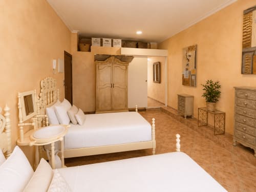 Espacioso dormitorio de apartamento frente al mar en Baiona con camas gemelas, armario de madera y decoración costera