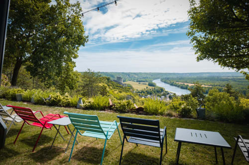 Colorful chairs on grassy terrace overlooking Seine River valley at La Roche Guyon, Giverny area