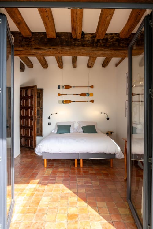 Chambre rustique aux poutres apparentes, linge blanc et rames décoratives au Paradis de Lucile, La Roche Guyon