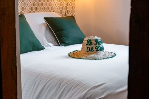 Lit aux oreillers turquoise et chapeau de paille au Paradis de Lucile B&B à La Roche Guyon, Giverny