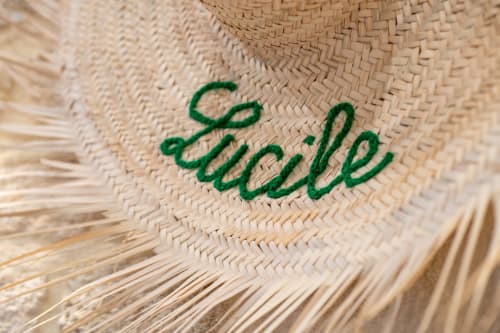Texte brodé vert « Lucile » sur chapeau de paille naturelle tissée aux bords effilochés au Paradis de Lucile B&B