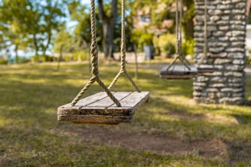 Balançoires rustiques aux sièges en bois dans le jardin champêtre du Paradis de Lucile, La Roche Guyon