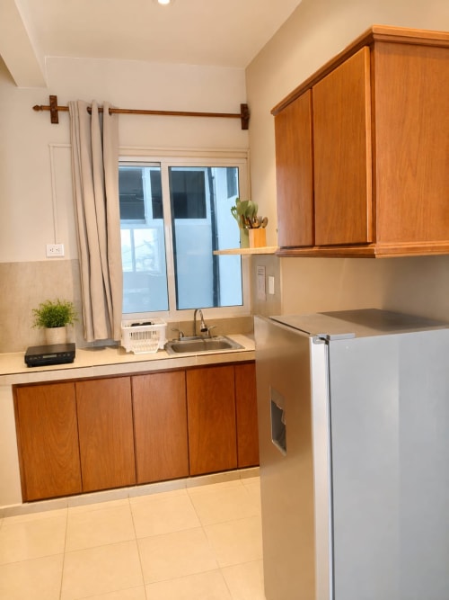 Cocina moderna en Suite 3 del Hotel Isla Mujeres Centro con gabinetes de madera, electrodomésticos de acero inoxidable y vista a la ventana