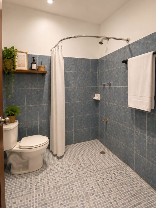 Baño moderno con ducha tipo walk-in, paredes de azulejo pizarra y piso de mosaico en la suite Hotel Isla Mujeres Centro, México
